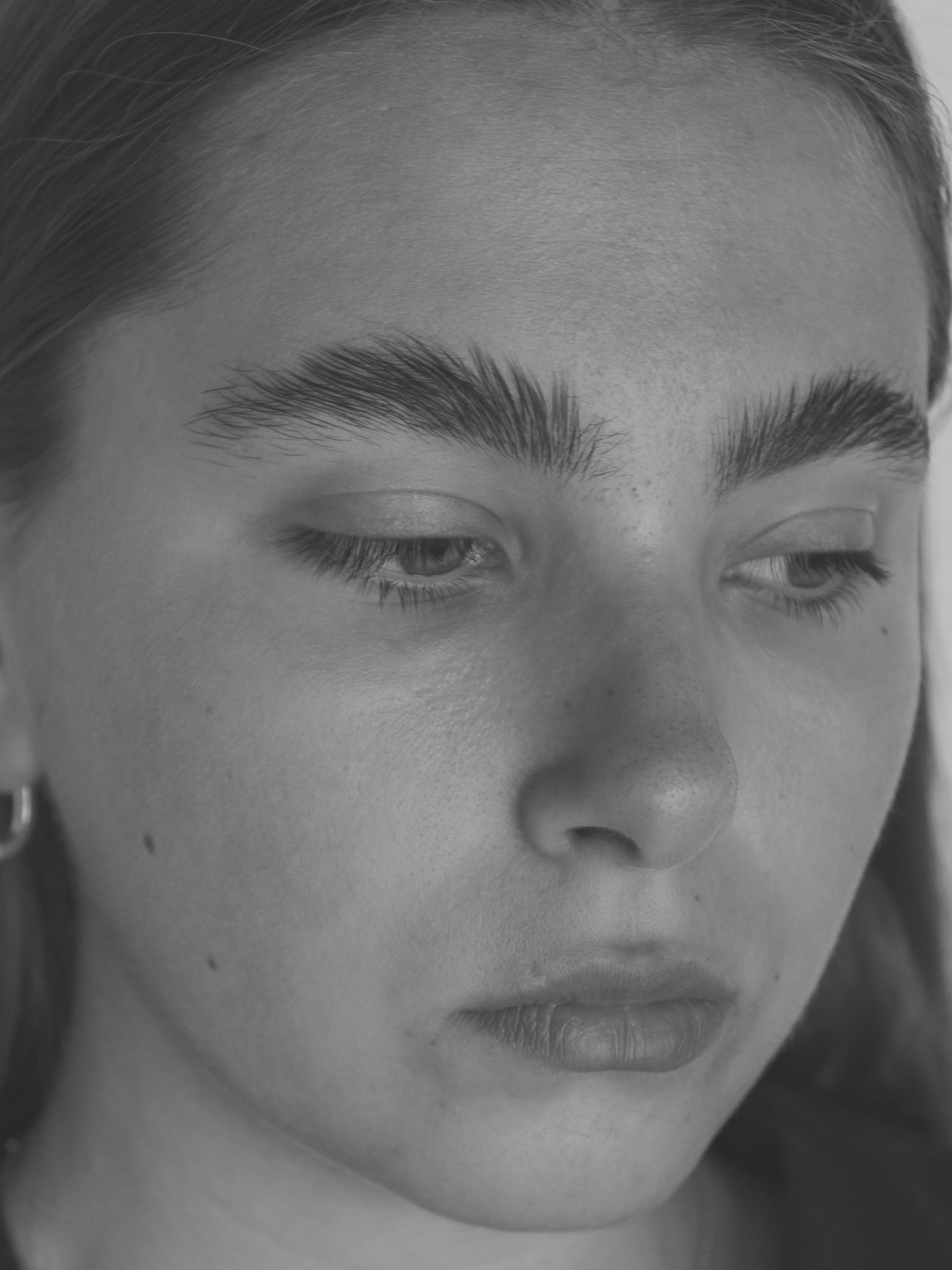 Close-up portrait of young woman with downcast eyes