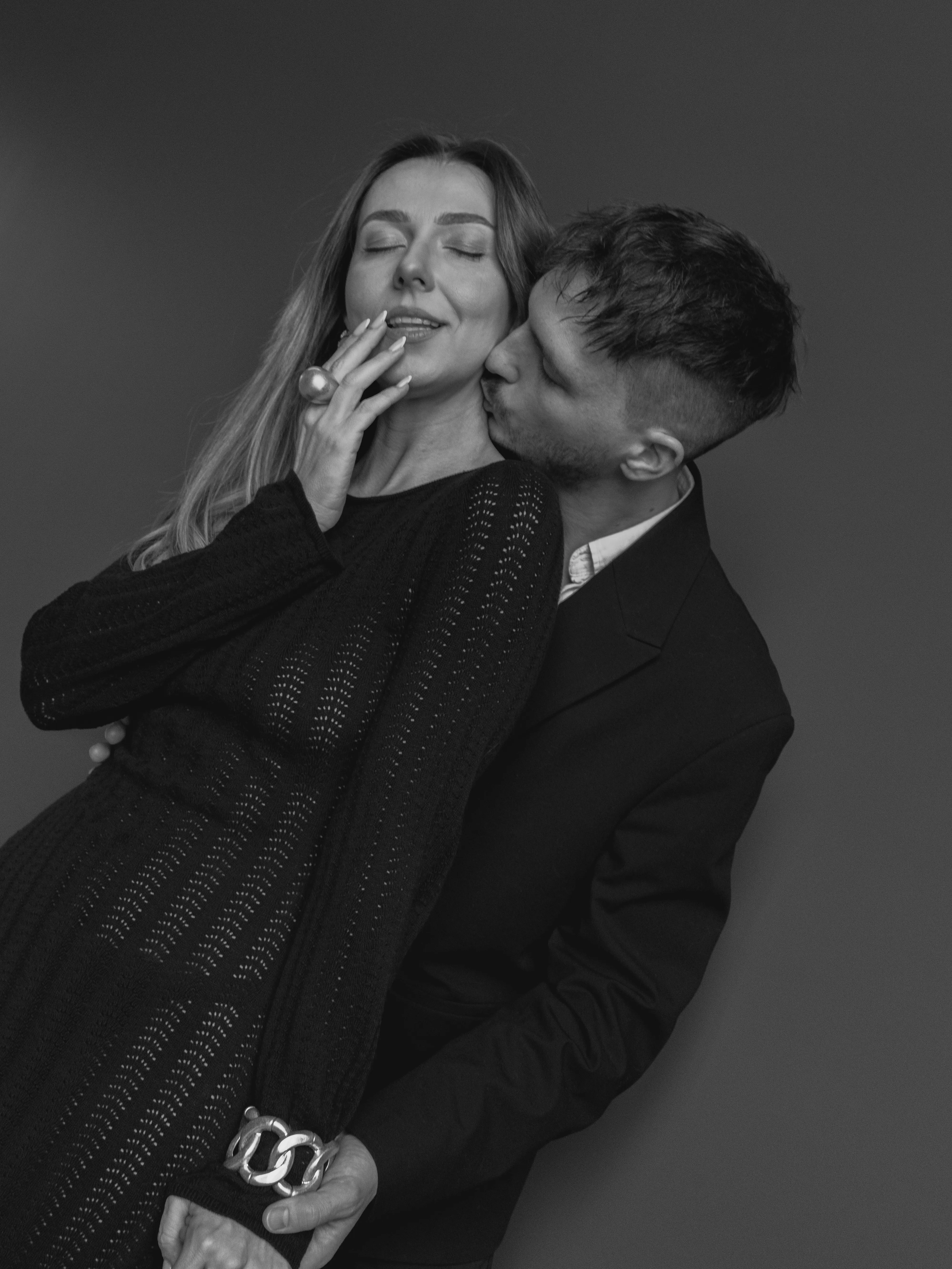 Couple embracing, man kissing woman on the neck