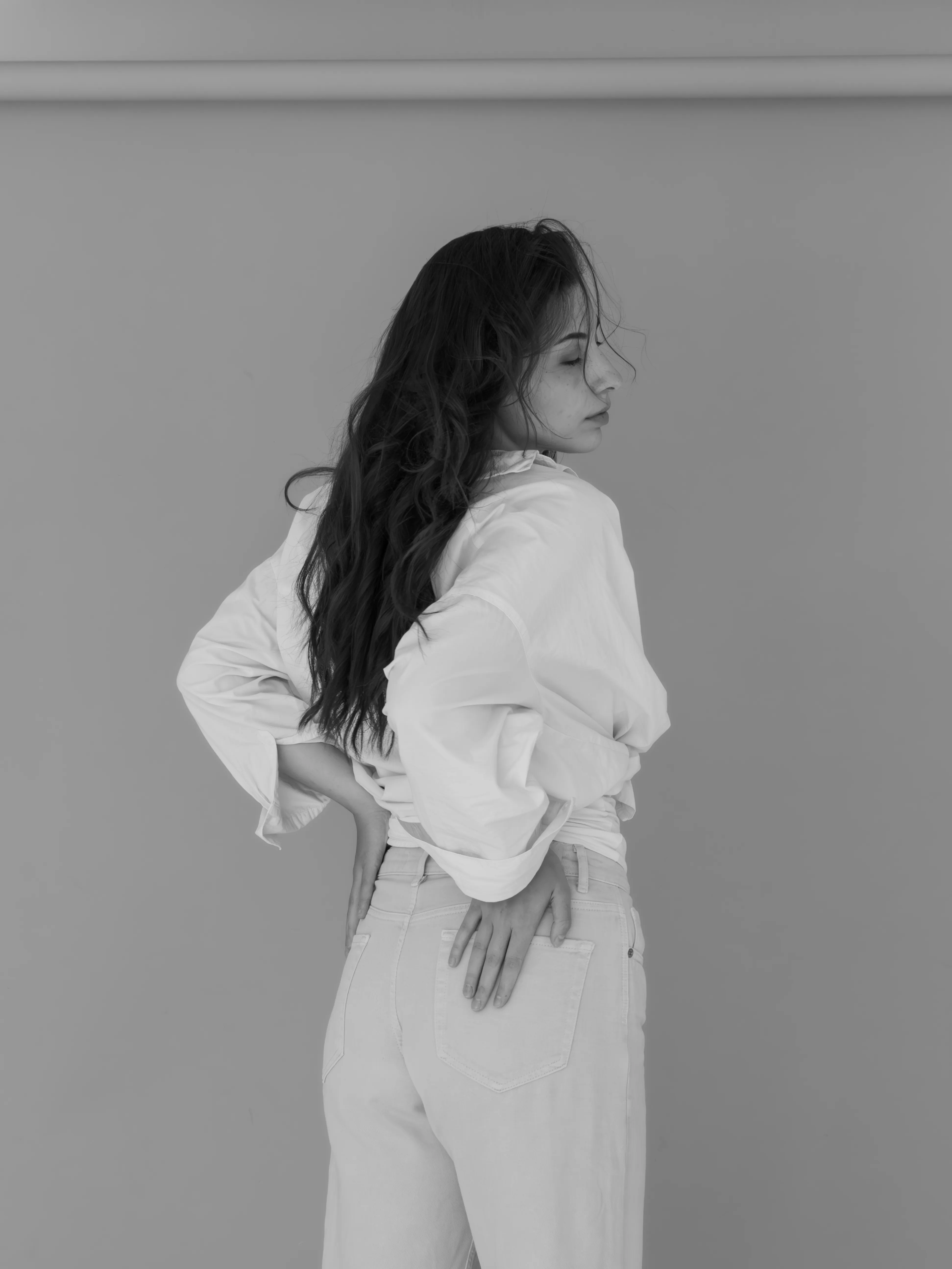 Woman in white shirt and pants, profile view