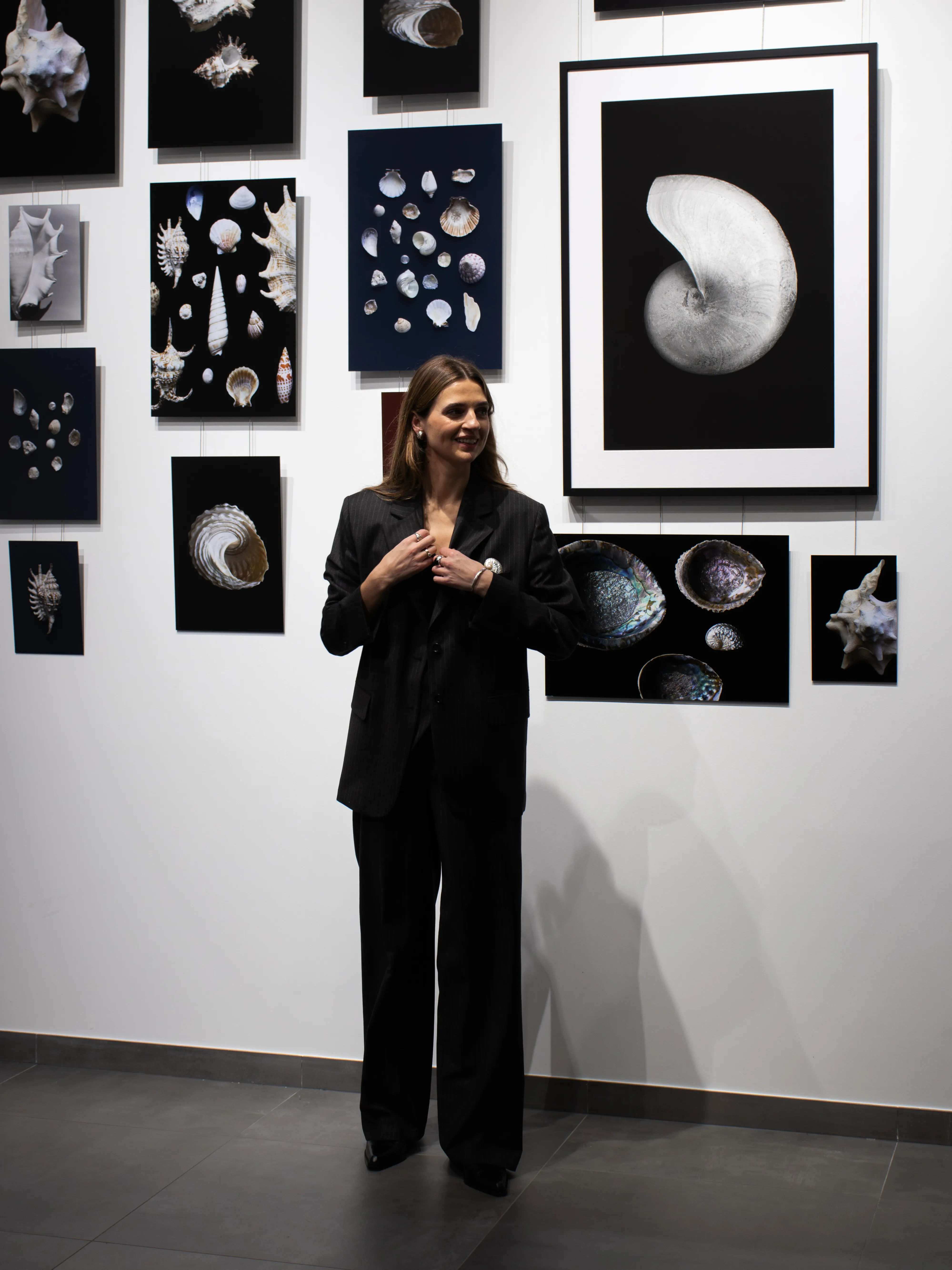 Woman in pinstripe suit standing before nautilus shell artwork