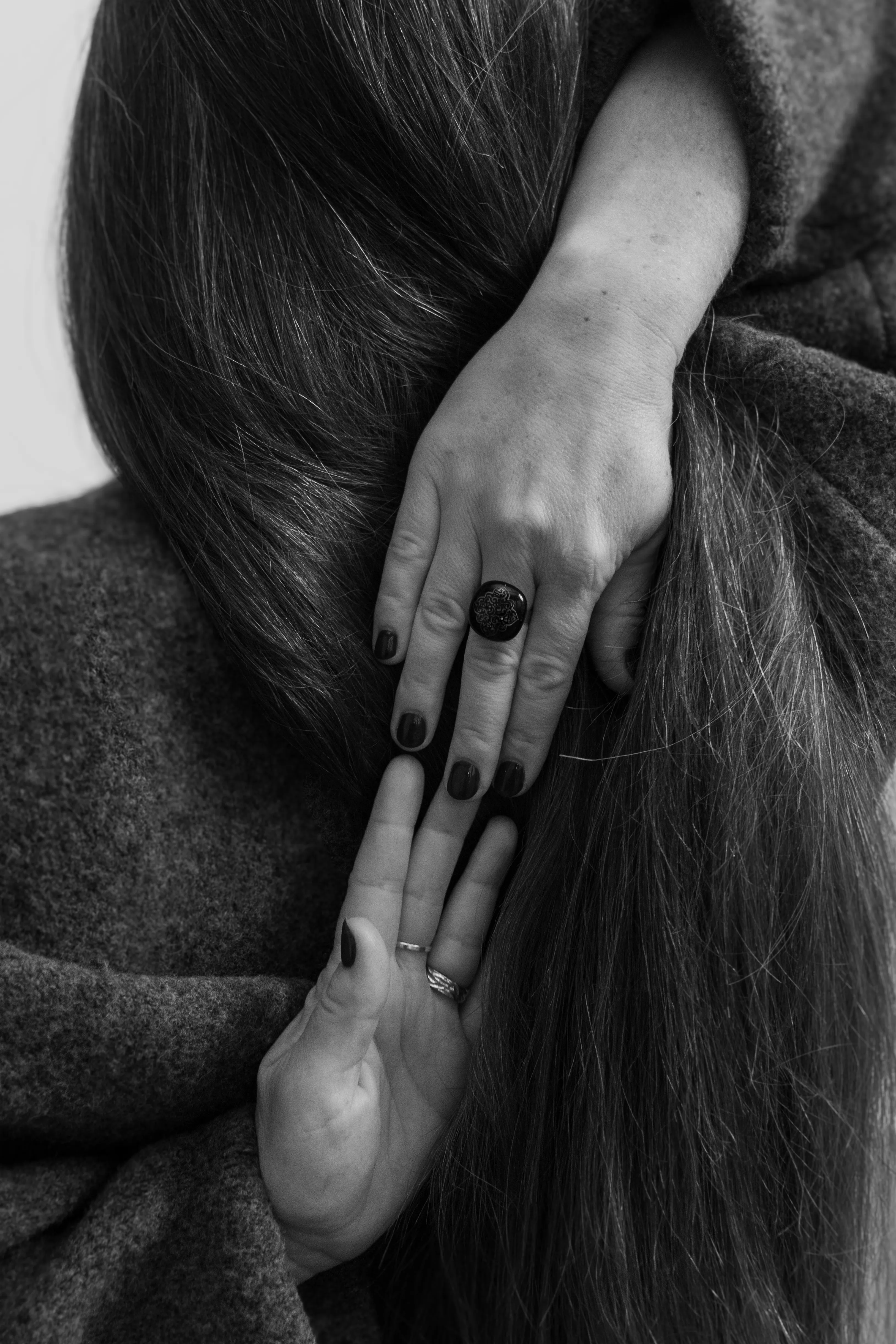 Hand touching hair from behind with rings