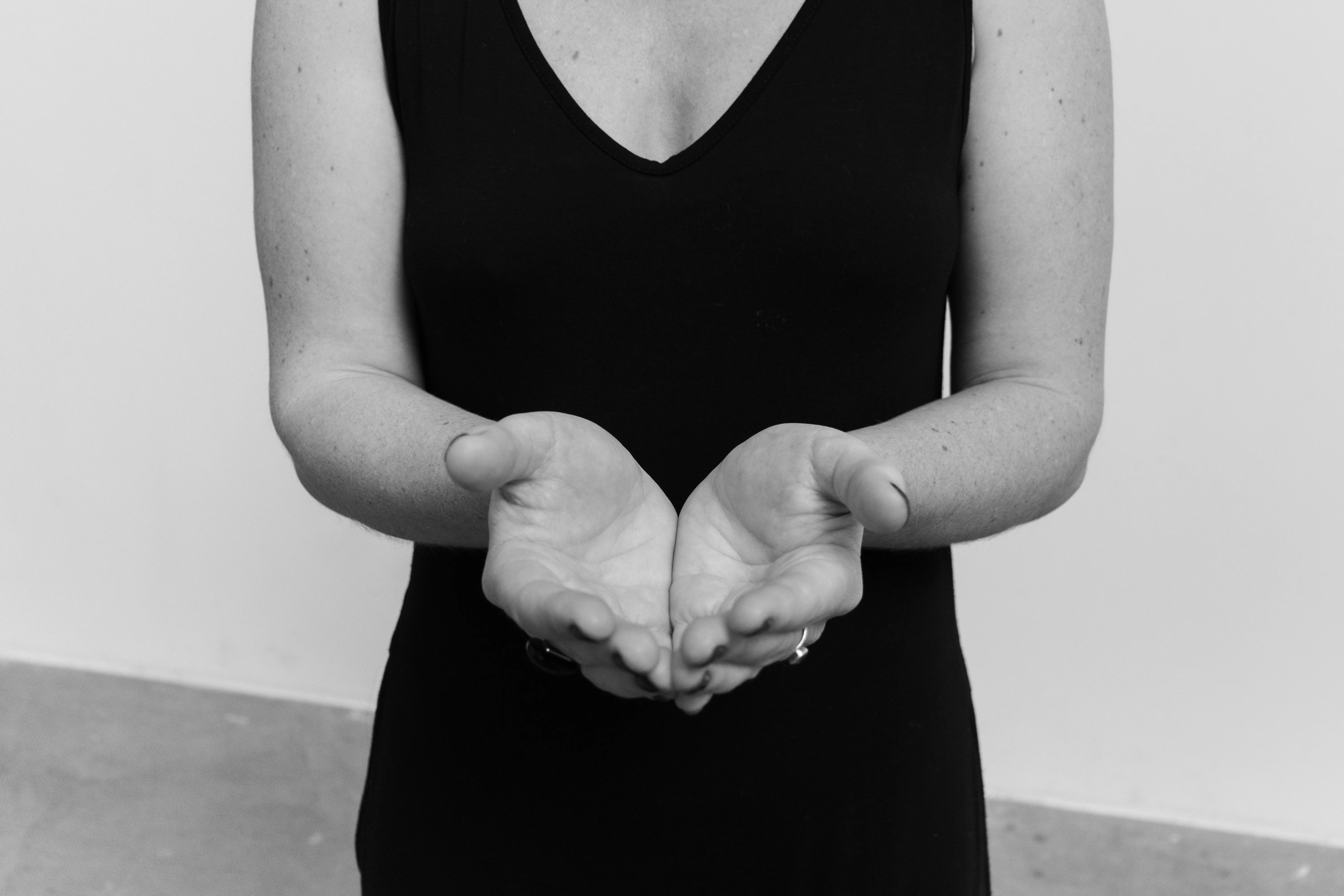 Woman in black dress with cupped hands