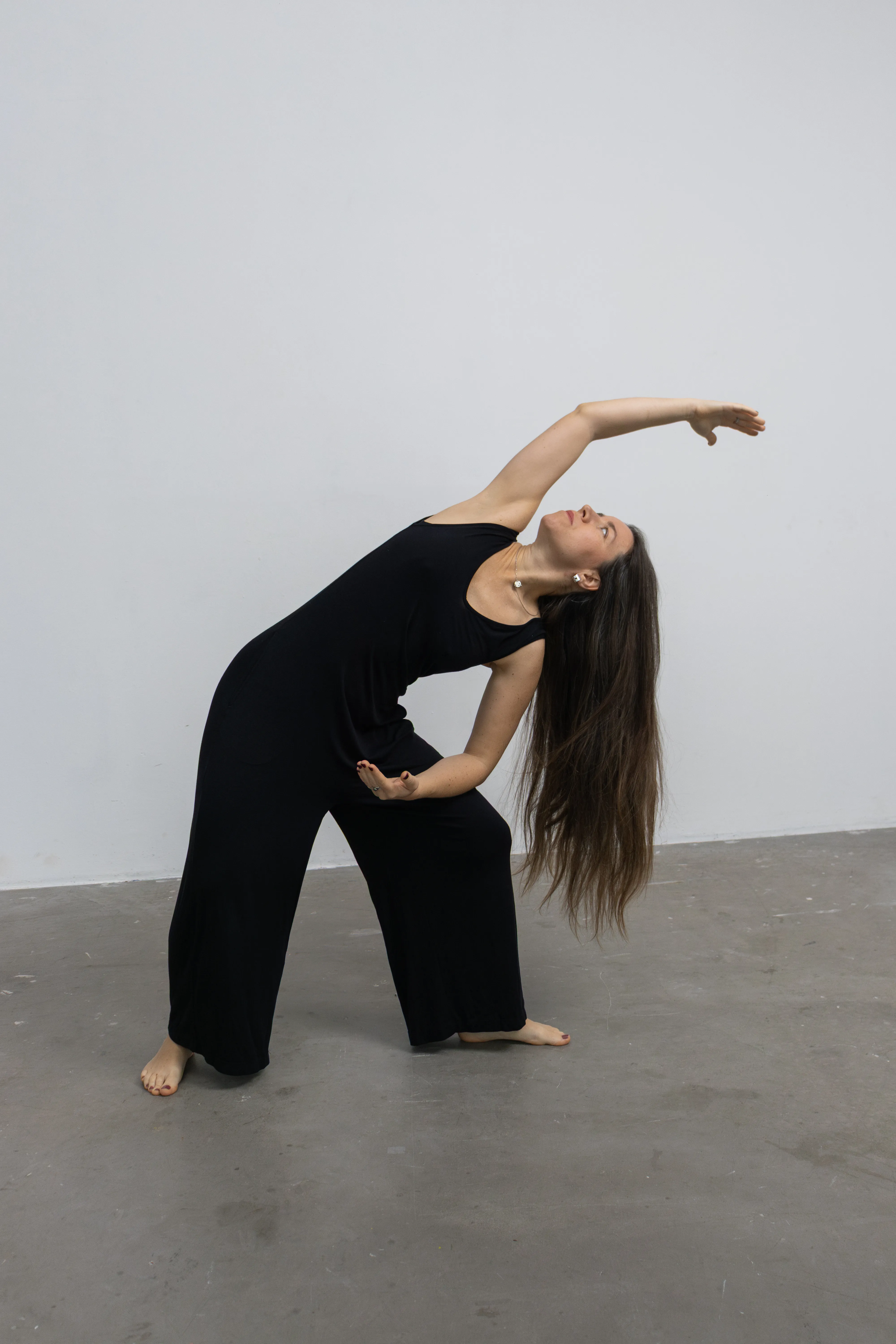 Dancer in black bending gracefully in studio
