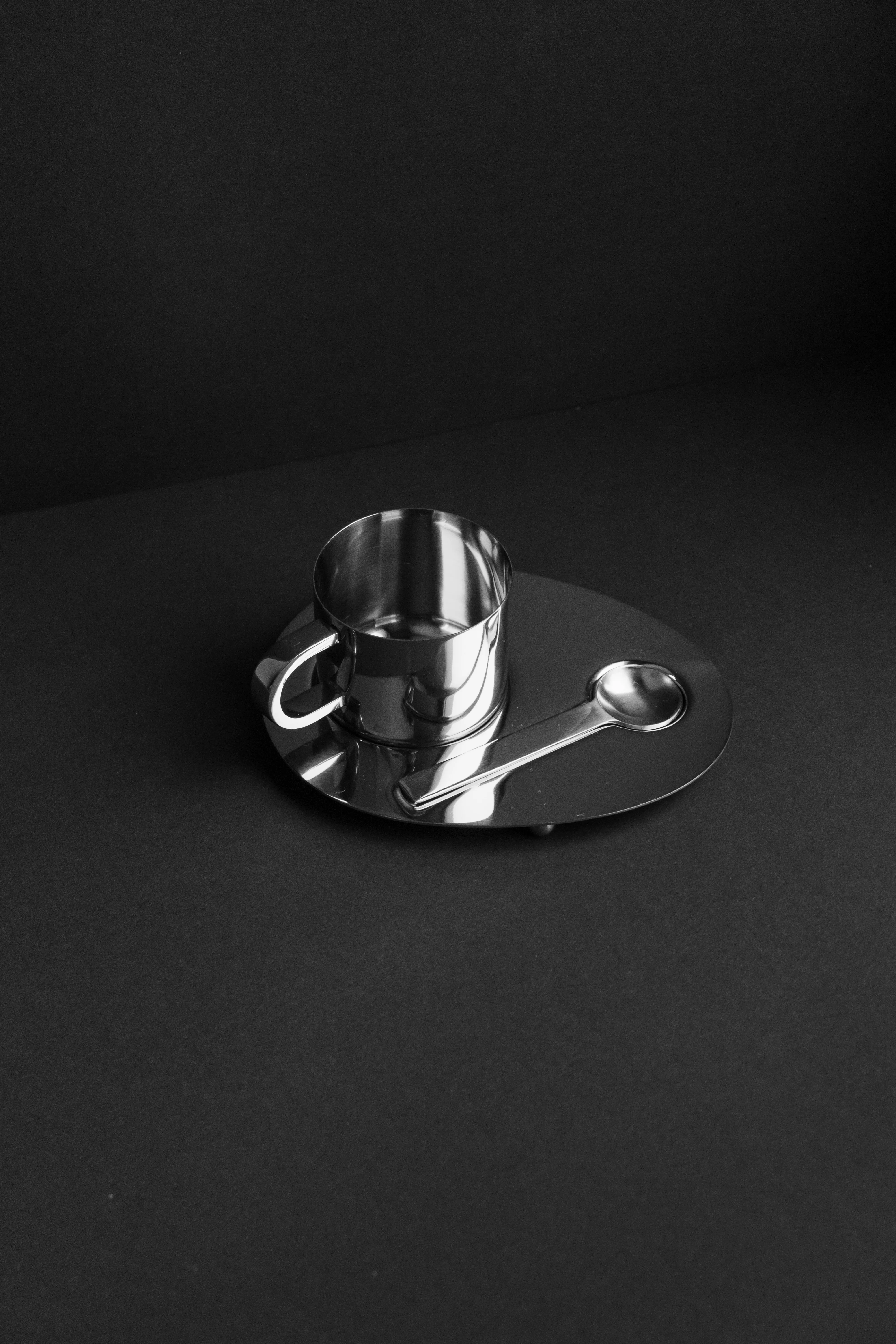 Silver espresso cup on reflective tray