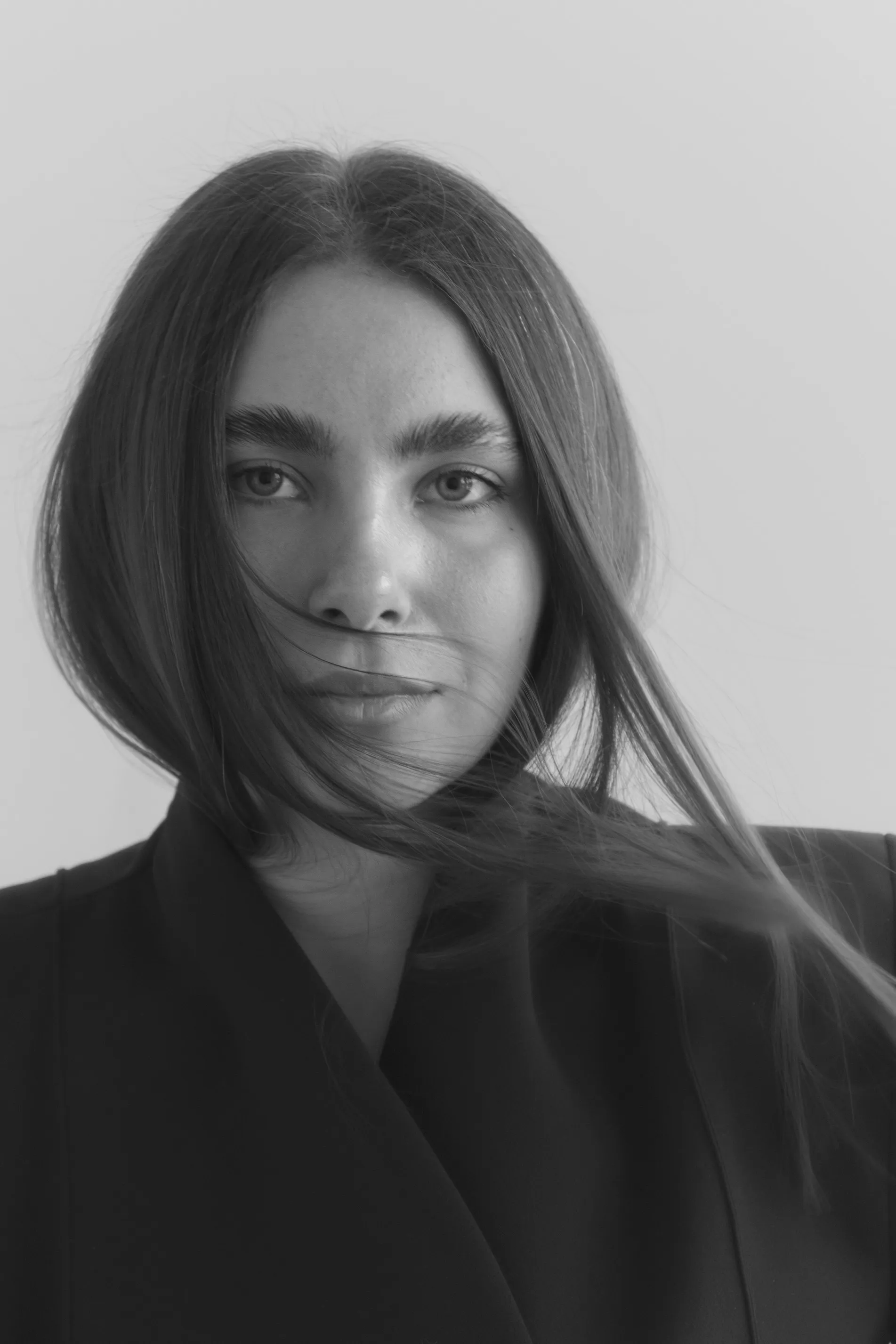 Close-up black and white portrait with wind-blown hair