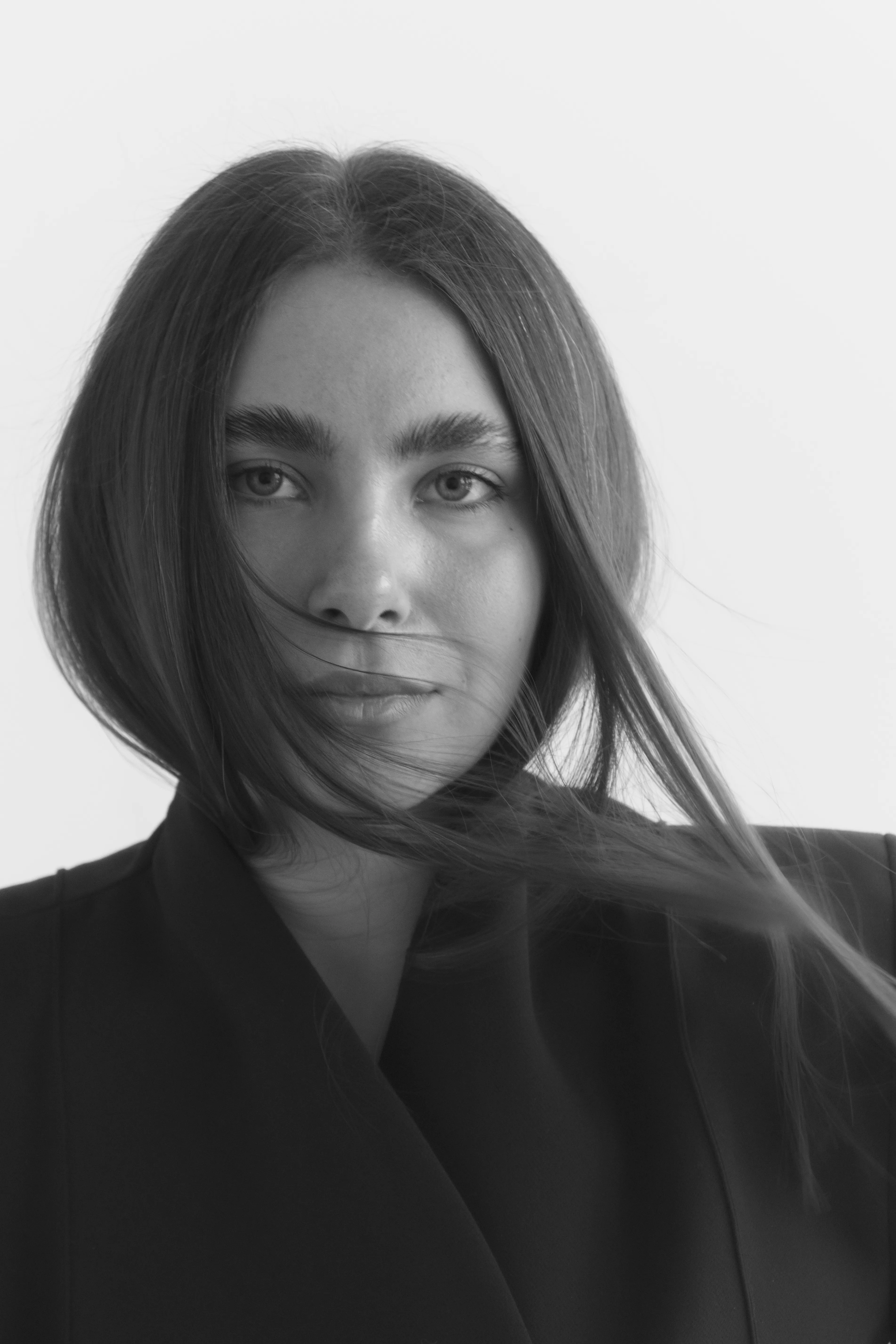 Close-up black and white portrait with wind-blown hair