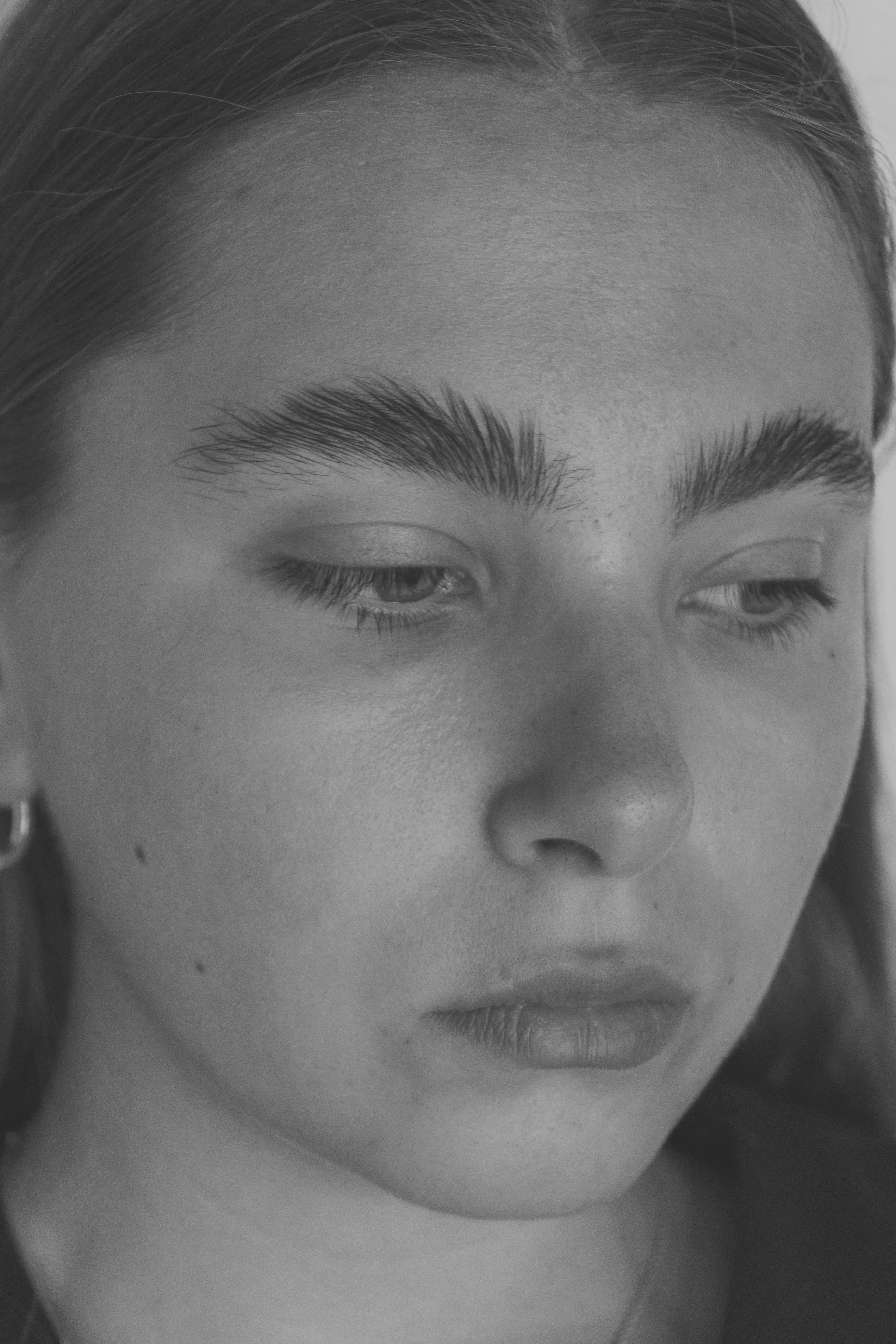 Close-up portrait of young woman with downcast eyes